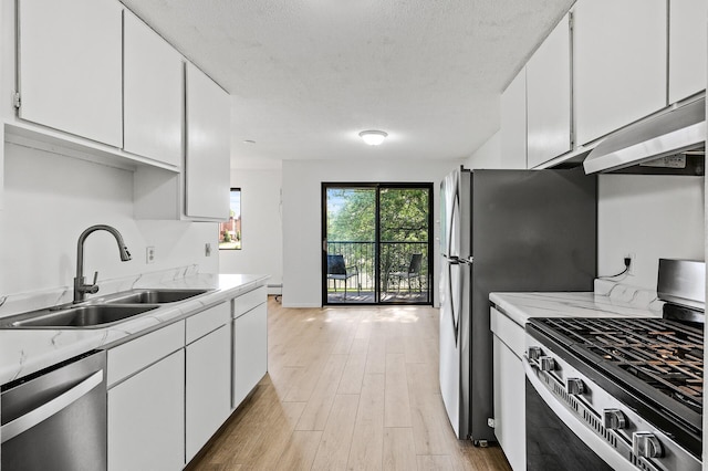 4101 Parklawn Ave Unit 320, Edina, MN 55435 - kitchen featuring stainless steel appliances, light countertops, under cabinet range hood, light wood-style floors, and white cabinetry