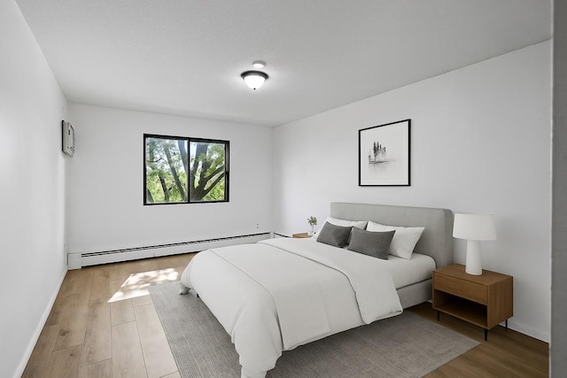 4101 Parklawn Ave Unit 320, Edina, MN 55435 - bedroom featuring a baseboard heating unit and wood finished floors