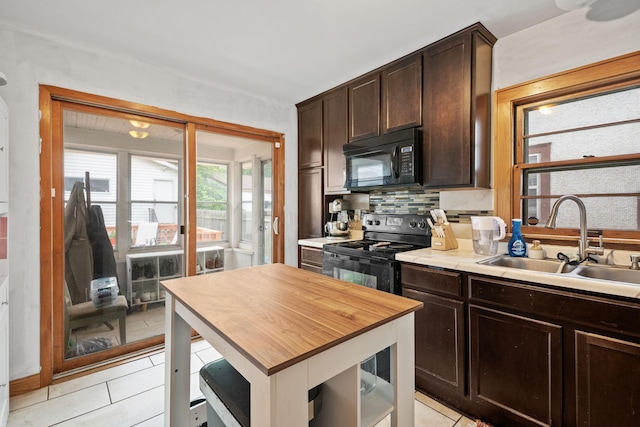 3734 Emerson Ave N, Minneapolis, MN 55412 - kitchen with black appliances, wood counters, dark brown cabinets, tasteful backsplash, and light tile patterned flooring