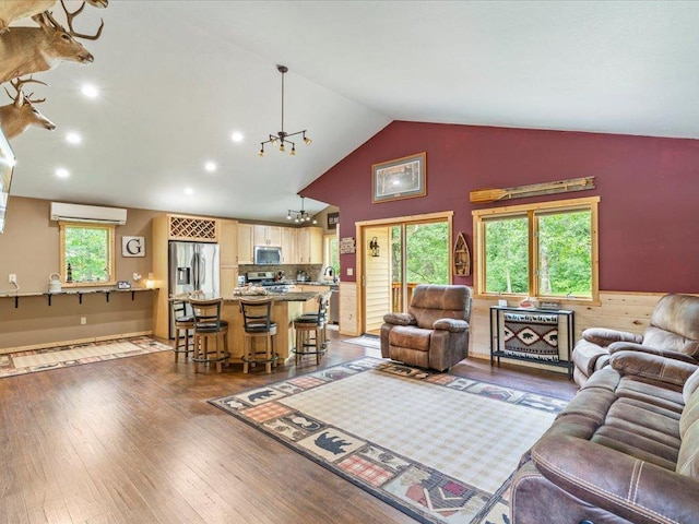 31591 Summer Dr, Breezy Point, MN 56472 - living area with a wall unit AC, a chandelier, vaulted ceiling, wood finished floors, and recessed lighting