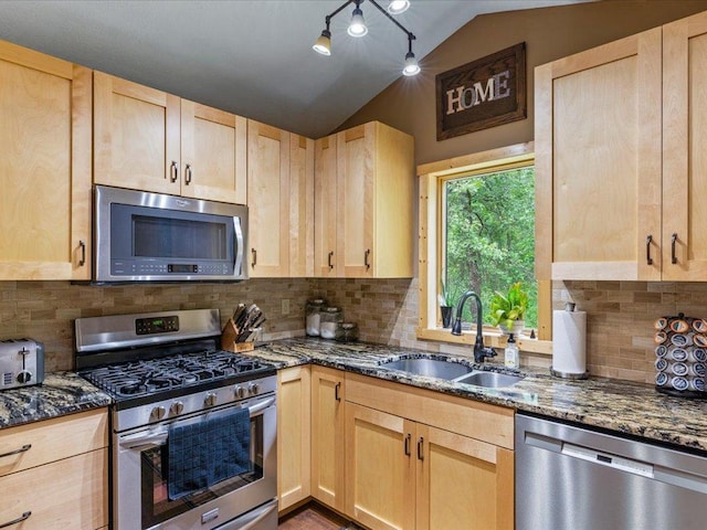 31591 Summer Dr, Breezy Point, MN 56472 - kitchen with appliances with stainless steel finishes, light brown cabinets, vaulted ceiling, dark stone countertops, and backsplash