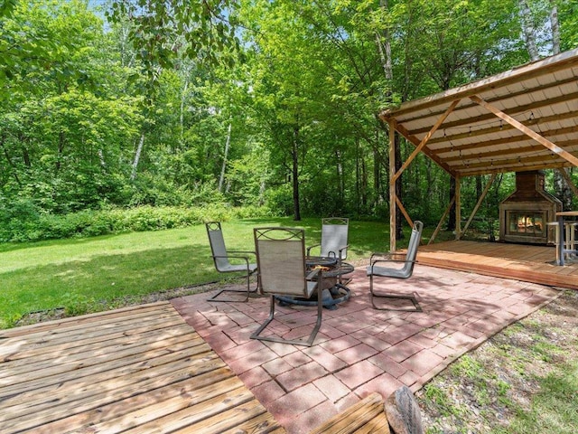 31591 Summer Dr, Breezy Point, MN 56472 - wooden deck with a warm lit fireplace, a patio, a lawn, and outdoor dining space