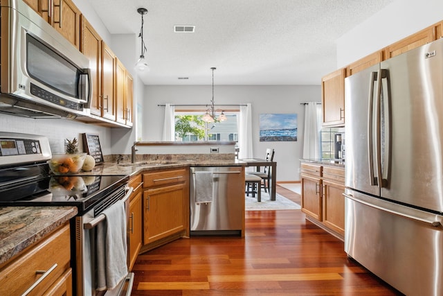 1343 Yorkshire Ln, Shakopee, MN 55379 - kitchen featuring stainless steel appliances, dark wood-style floors, a peninsula, decorative light fixtures, and a chandelier
