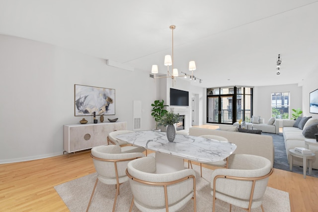 408 1st St Unit 310, Minneapolis, MN 55401 - dining area with a glass covered fireplace, light wood-style flooring, and a chandelier