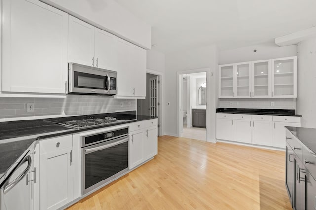 408 1st St Unit 310, Minneapolis, MN 55401 - kitchen with stainless steel appliances, backsplash, white cabinets, and glass insert cabinets