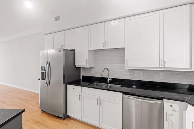 408 1st St Unit 310, Minneapolis, MN 55401 - kitchen with appliances with stainless steel finishes, white cabinetry, light wood-style flooring, and decorative backsplash