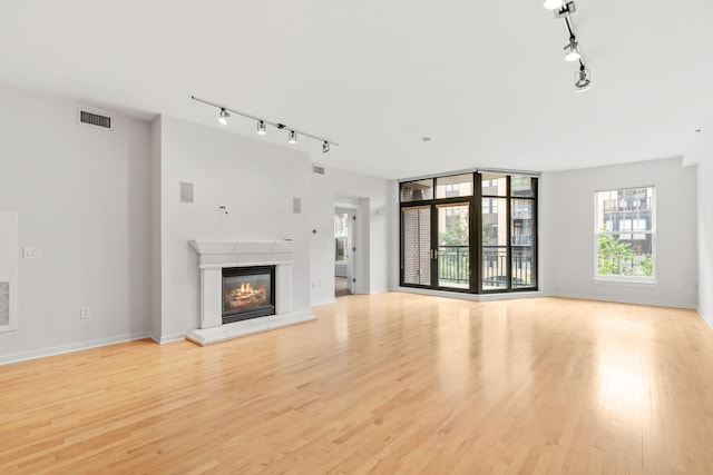 408 1st St Unit 310, Minneapolis, MN 55401 - unfurnished living room with track lighting, light wood-type flooring, and a glass covered fireplace