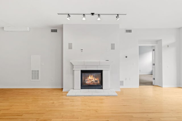 408 1st St Unit 310, Minneapolis, MN 55401 - unfurnished living room featuring light wood finished floors, track lighting, and a fireplace