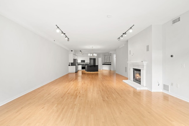 408 1st St Unit 310, Minneapolis, MN 55401 - unfurnished living room featuring track lighting, a glass covered fireplace, and light wood-type flooring