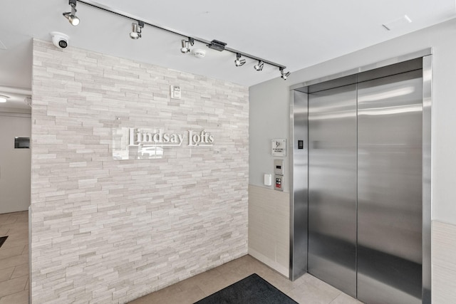408 1st St Unit 310, Minneapolis, MN 55401 - bathroom featuring elevator, tile patterned flooring, track lighting, and tile walls