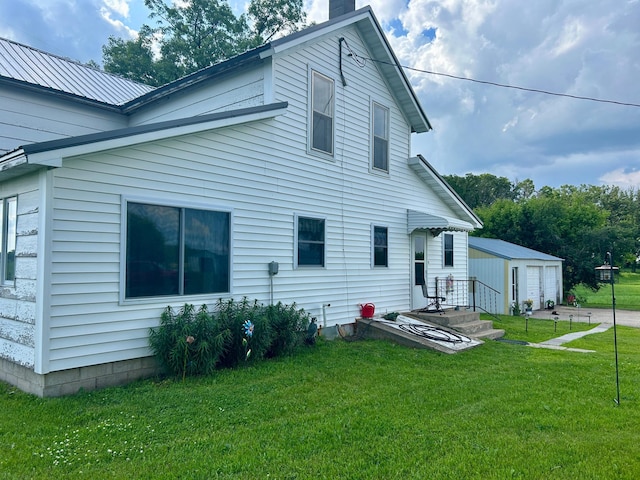 31231 568th Ave, Deer Creek Twp, MN 56527 - back of property featuring an outbuilding, a yard, a garage, and a chimney