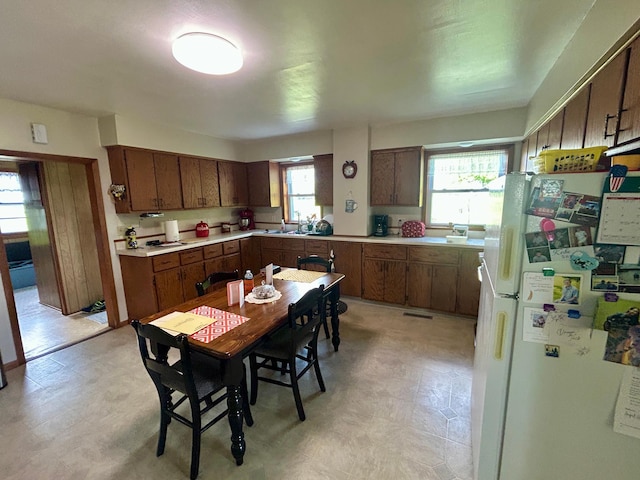 31231 568th Ave, Deer Creek Twp, MN 56527 - kitchen featuring freestanding refrigerator, light flooring, light countertops, and brown cabinetry