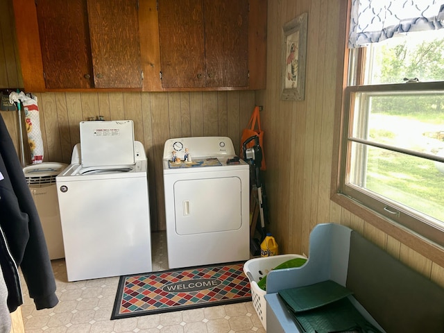 31231 568th Ave, Deer Creek Twp, MN 56527 - laundry room with washing machine and clothes dryer, wooden walls, cabinet space, and plenty of natural light