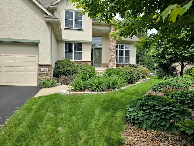 2011 117th Ln NE, Blaine, MN 55449 - view of front of home featuring stone siding, stucco siding, a front lawn, and driveway