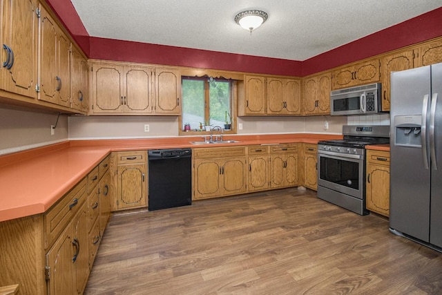 2246 Vivian Ln, Saint Paul, MN 55119 - kitchen with appliances with stainless steel finishes, dark wood finished floors, brown cabinetry, a textured ceiling, and light countertops