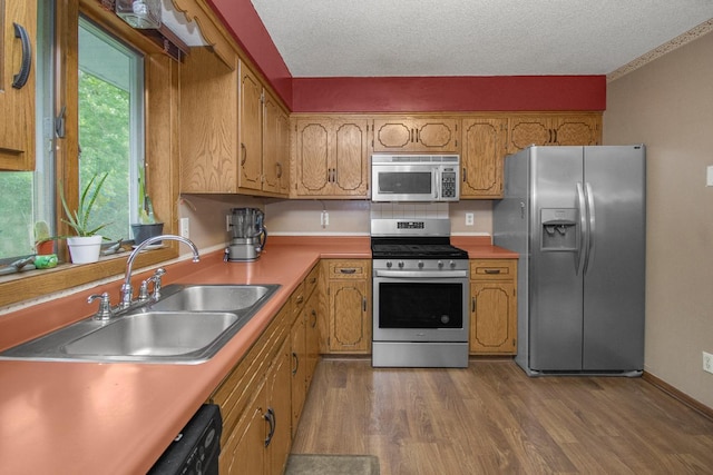 2246 Vivian Ln, Saint Paul, MN 55119 - kitchen with stainless steel appliances, wood finished floors, brown cabinets, light countertops, and a textured ceiling
