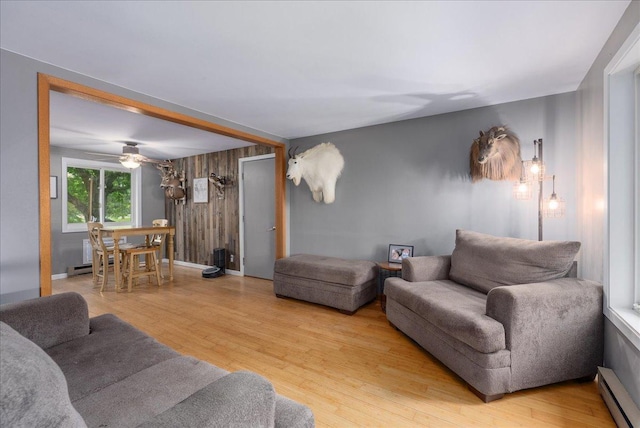1145 Norton St, Hammond, WI 54015 - living room featuring a baseboard heating unit, wood finished floors, a ceiling fan, and wood walls