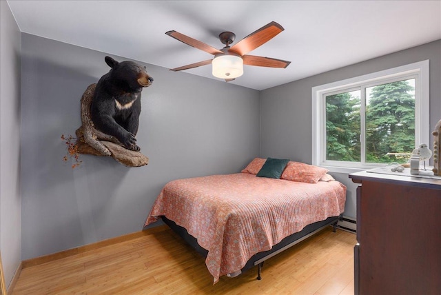1145 Norton St, Hammond, WI 54015 - bedroom with light wood-style flooring, a baseboard radiator, and a ceiling fan