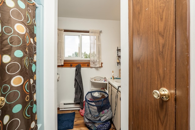 33406 151st Ave, Montgomery, MN 56069 - full bath with baseboard heating, vanity, wood finished floors, and a shower with shower curtain