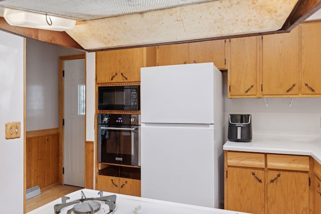 20240 Saint Croix Trl N, Scandia, MN 55073 - kitchen with freestanding refrigerator, wall oven, black microwave, light countertops, and wood walls