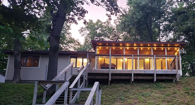20758 Pike Ave, Aitkin, MN 56431 - back of house at dusk featuring stairs and a wooden deck