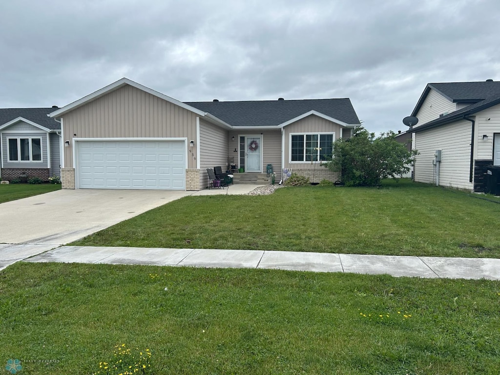 959 29th Ave W, West Fargo, ND 58078 - ranch-style house featuring an attached garage, board and batten siding, concrete driveway, a front yard, and brick siding