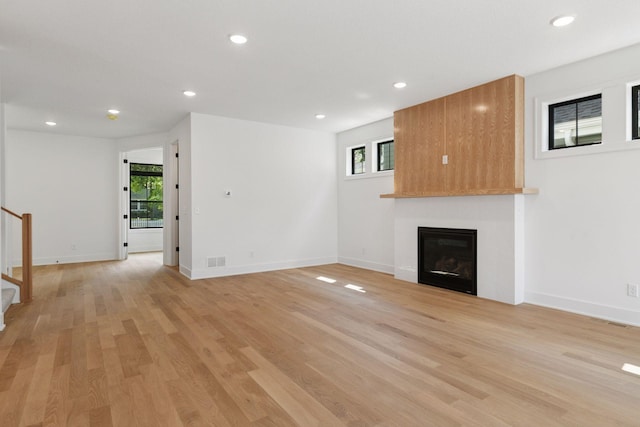 2084 Palace Ave, Saint Paul, MN 55105 - unfurnished living room with stairs, a large fireplace, light wood-type flooring, and recessed lighting