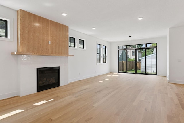 2084 Palace Ave, Saint Paul, MN 55105 - unfurnished living room featuring a tiled fireplace, light wood finished floors, and recessed lighting