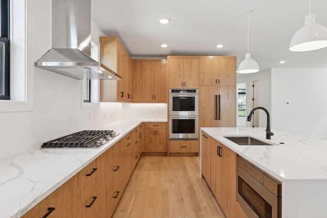 2084 Palace Ave, Saint Paul, MN 55105 - kitchen featuring wall chimney range hood, stainless steel appliances, light wood-type flooring, decorative light fixtures, and light stone countertops