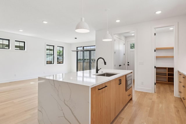 2084 Palace Ave, Saint Paul, MN 55105 - kitchen featuring modern cabinets, light wood-style flooring, a kitchen island with sink, pendant lighting, and recessed lighting