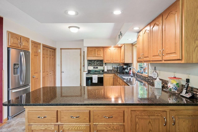 62405 Delta Lake Rd, Delta, WI 54847 - kitchen with appliances with stainless steel finishes, a peninsula, dark stone counters, recessed lighting, and brown cabinetry
