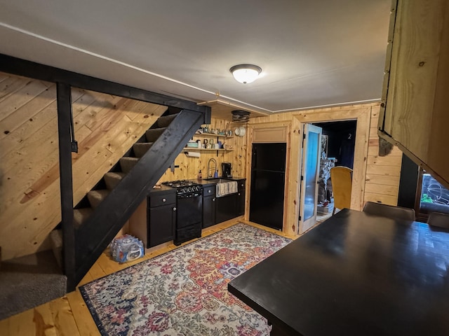 17700 78th St SW, Cokato, MN 55321 - kitchen with black appliances, wood walls, open shelves, and light wood-type flooring