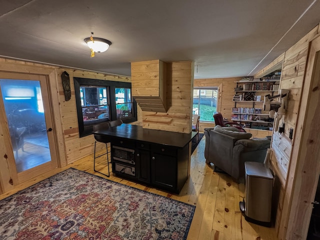 17700 78th St SW, Cokato, MN 55321 - kitchen featuring wooden walls, light wood finished floors, dark cabinetry, and open floor plan