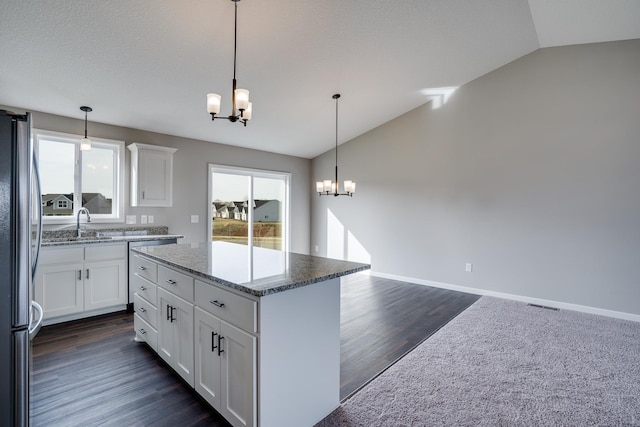 17360 62nd St NE, Otsego, MN 55330 - kitchen featuring a chandelier, freestanding refrigerator, vaulted ceiling, white cabinetry, and light stone counters
