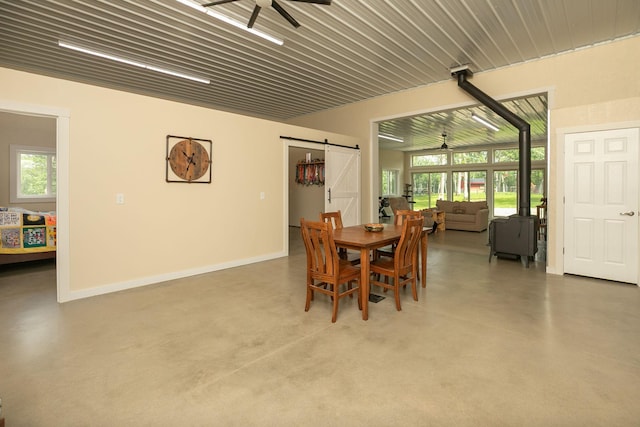 9005 80th Ave SE, Orion Twp, MN 55923 - dining room with ceiling fan, a barn door, and finished concrete flooring