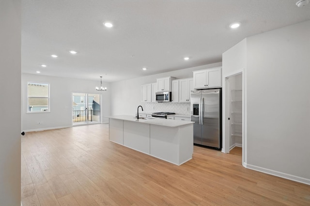 6570 Jody Ave S, Cottage Grove, MN 55016 - kitchen featuring appliances with stainless steel finishes, a chandelier, light countertops, decorative backsplash, and light wood finished floors