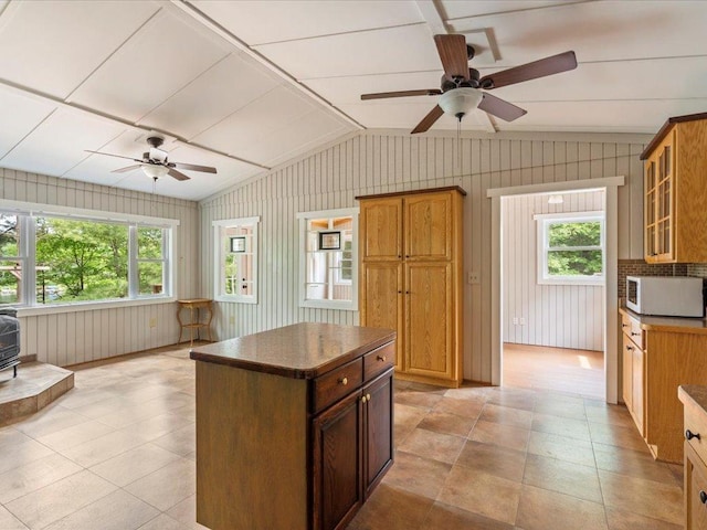 33277 308th Ln, Aitkin, MN 56431 - kitchen with white microwave, a ceiling fan, vaulted ceiling, glass insert cabinets, and dark countertops