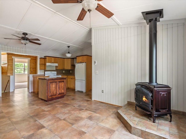 33277 308th Ln, Aitkin, MN 56431 - kitchen with freestanding refrigerator, a ceiling fan, a wood stove, range, and under cabinet range hood