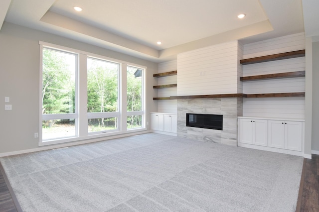 21705 Willys St NE, East Bethel, MN 55011 - unfurnished living room featuring a raised ceiling, recessed lighting, healthy amount of natural light, and a premium fireplace