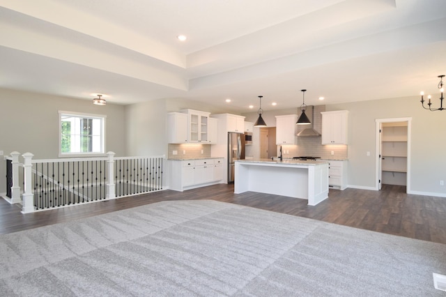 21705 Willys St NE, East Bethel, MN 55011 - kitchen with wall chimney exhaust hood, a chandelier, dark wood finished floors, appliances with stainless steel finishes, and tasteful backsplash