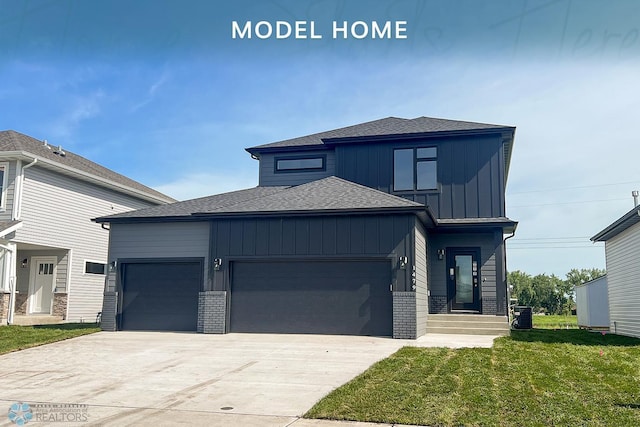 1479 66th Ave S, Fargo, ND 58104 - view of front of house with an attached garage, board and batten siding, driveway, a front lawn, and roof with shingles