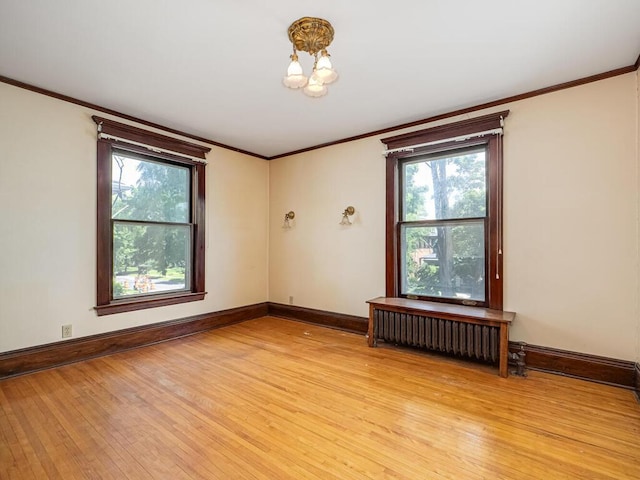 2320 Humboldt Ave S, Minneapolis, MN 55405 - unfurnished room featuring light wood-style flooring, radiator heating unit, ornamental molding, and a chandelier