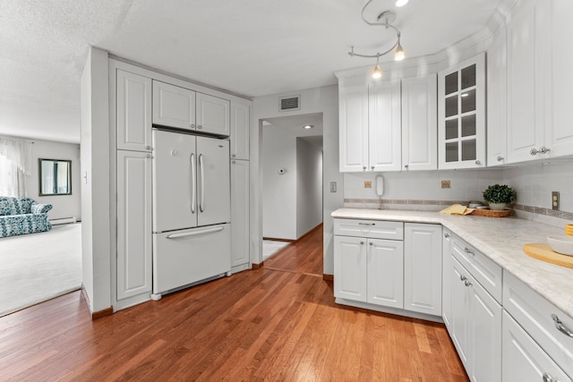 2485 Canabury Dr Unit 112, Little Canada, MN 55117 - kitchen with freestanding refrigerator, glass insert cabinets, baseboard heating, light countertops, and white cabinets