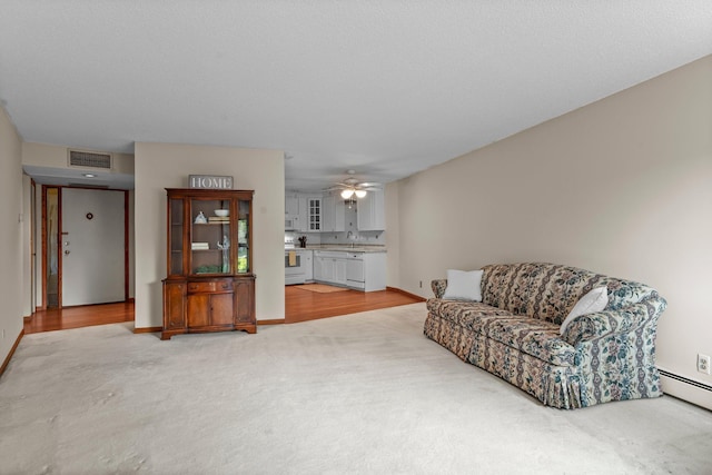 2485 Canabury Dr Unit 112, Little Canada, MN 55117 - living room featuring light colored carpet, ceiling fan, and a baseboard radiator