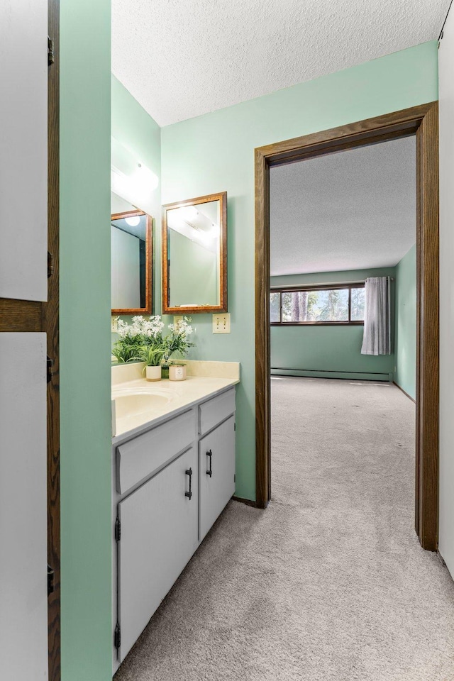 2485 Canabury Dr Unit 112, Little Canada, MN 55117 - bathroom featuring a textured ceiling, vanity, carpet flooring, and a baseboard heating unit