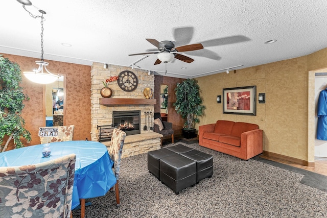 2485 Canabury Dr Unit 112, Little Canada, MN 55117 - living area featuring ceiling fan, a stone fireplace, and a textured ceiling