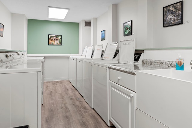 2485 Canabury Dr Unit 112, Little Canada, MN 55117 - laundry area with washing machine and clothes dryer, cabinet space, and light wood-style flooring