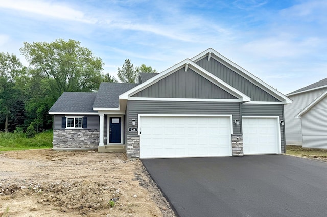 736 Yellowcrest St SW, Delano, MN 55328 - view of front of property featuring stone siding, a garage, driveway, and board and batten siding