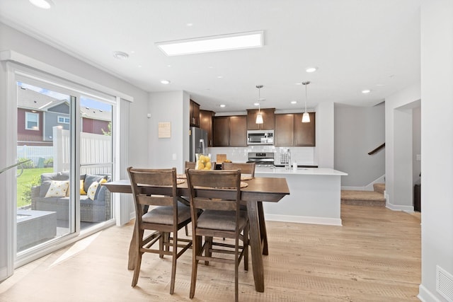 7237 Ada Dr, Lino Lakes, MN 55038 - dining room featuring light wood finished floors, stairway, and recessed lighting