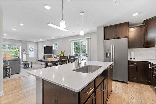 7237 Ada Dr, Lino Lakes, MN 55038 - kitchen with stainless steel fridge with ice dispenser, plenty of natural light, light countertops, dark brown cabinetry, and recessed lighting
